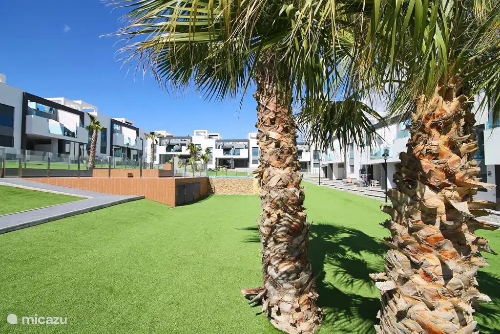 Tuin met speelveld, jeux de boulesbaan en palmen