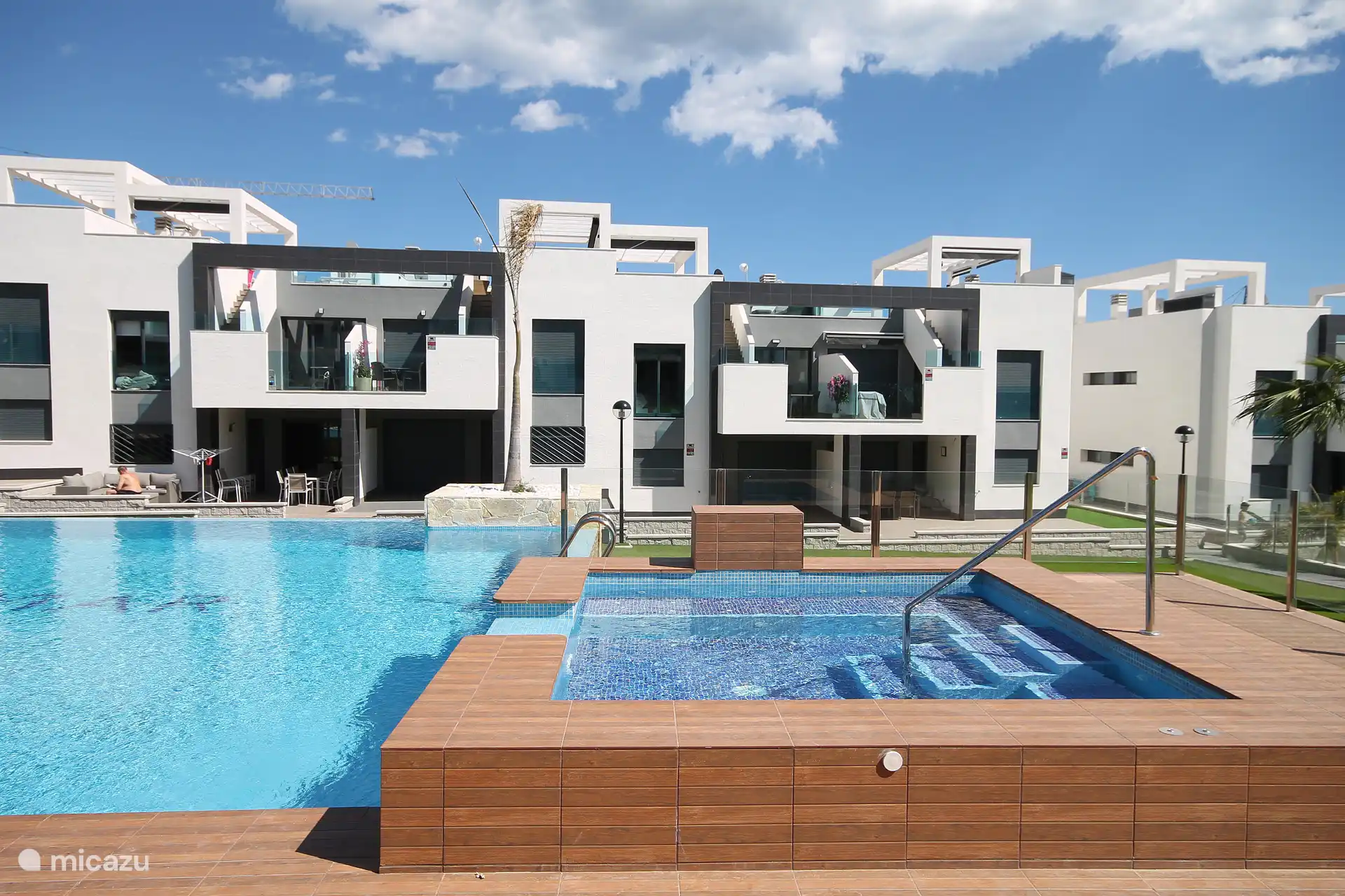 Achteraanzicht penthouse uitkijkend op zwembad met jacuzzi