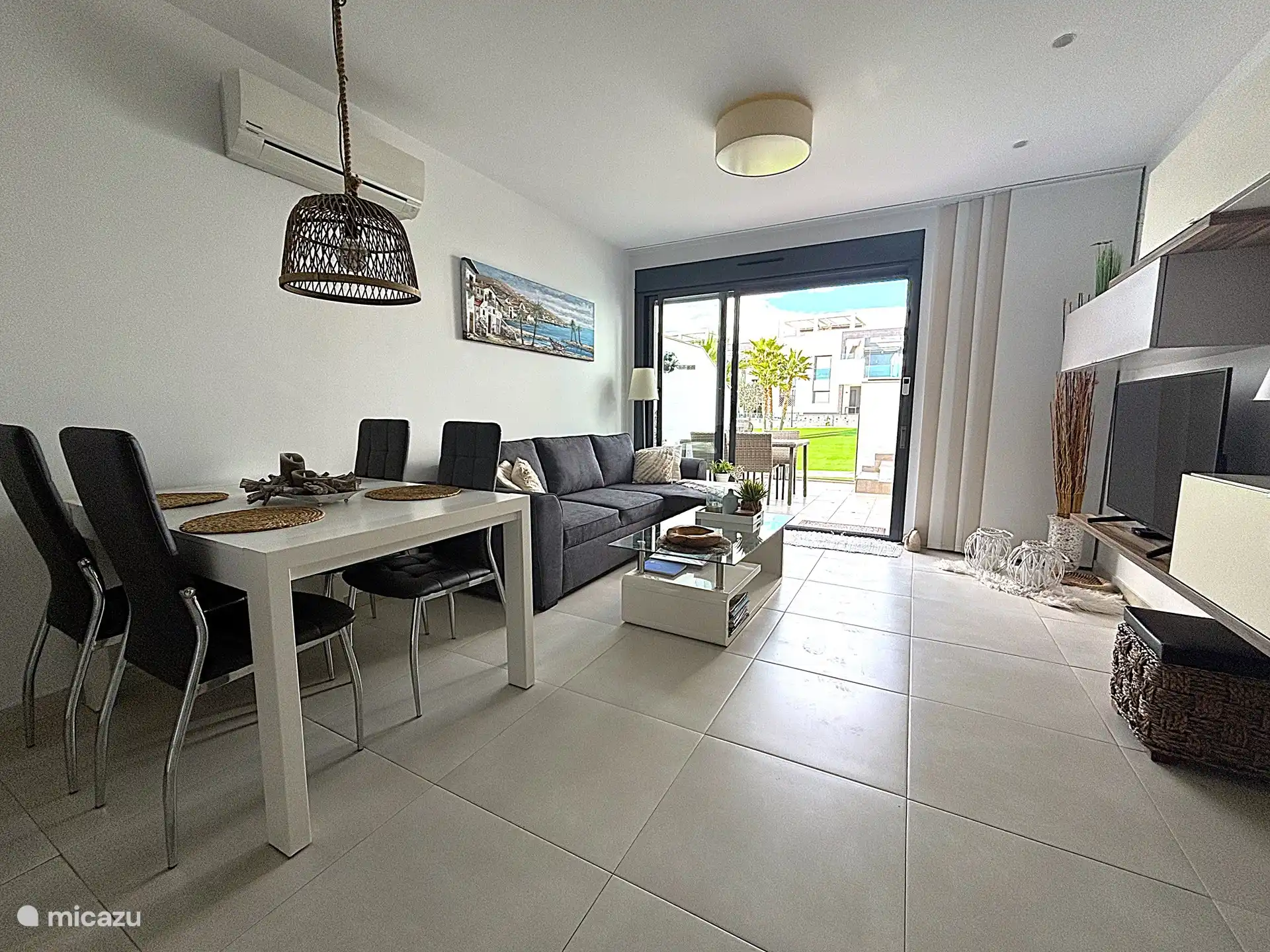 Woonkamer met sofa, TV en salontafel