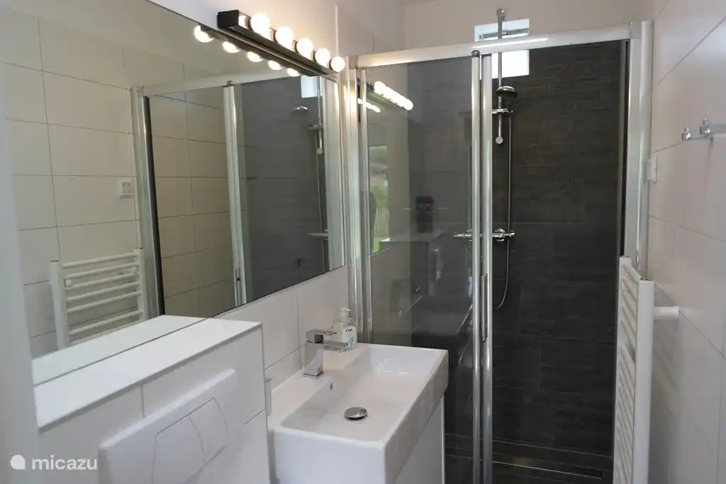 Salle de bain luxueuse avec grande douche, chauffage au sol et sèche-serviettes