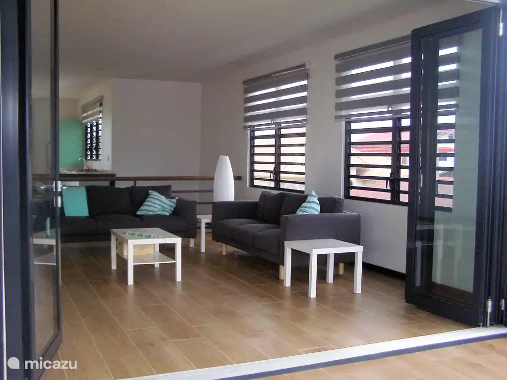 Das Wohnzimmer vom hinteren Balkon aus gesehen, mit vollständig geöffneten Falttüren