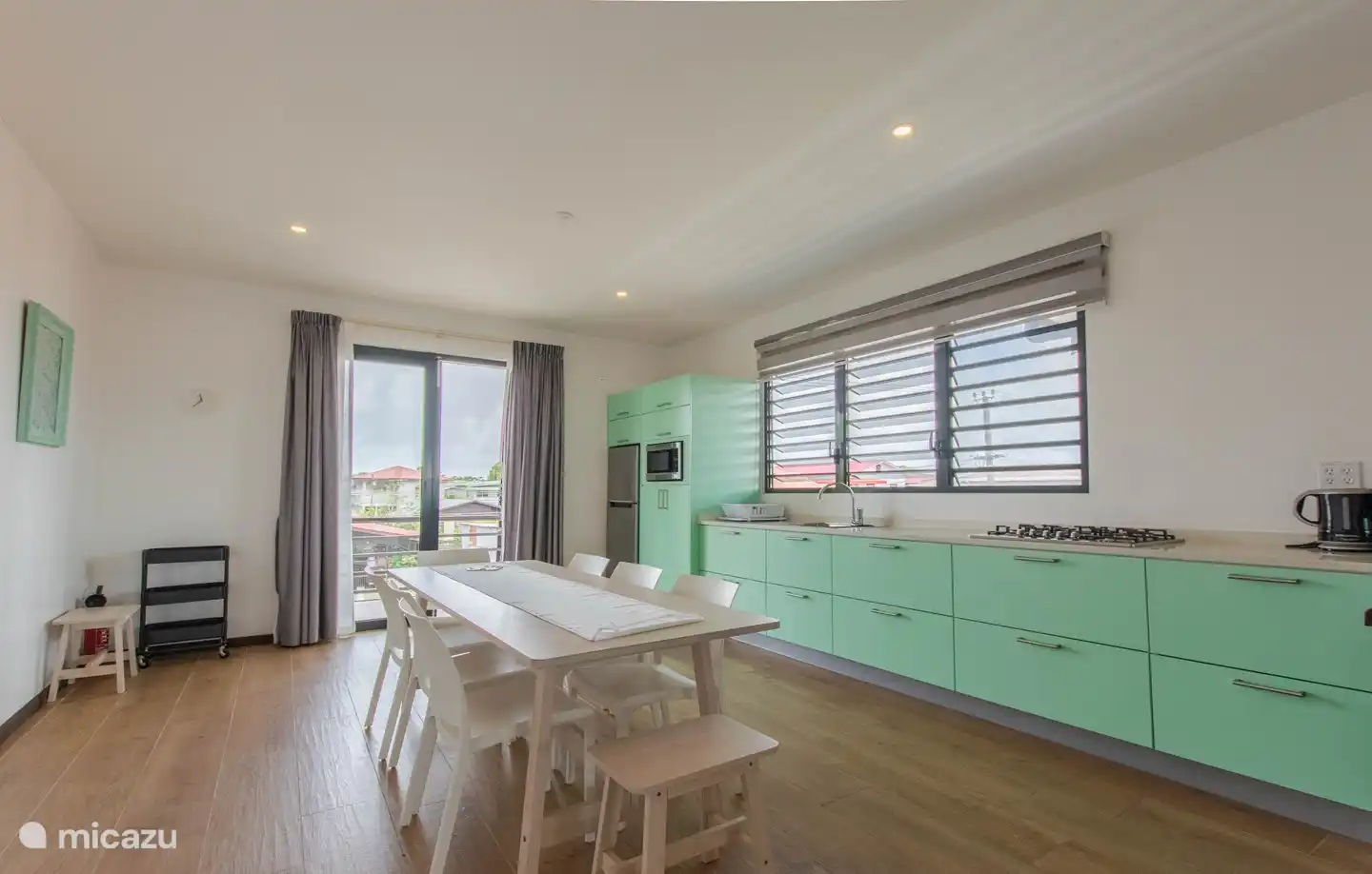 Links von der Treppe befindet sich eine Küche mit vielen Einbaugeräten. Geschirr und Kochgeschirr.