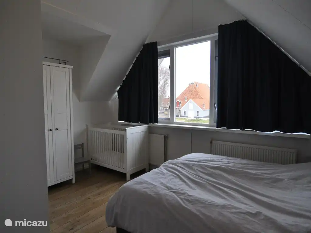 Geräumiges Schlafzimmer mit Blick auf das Dorfzentrum und den Bauernhof