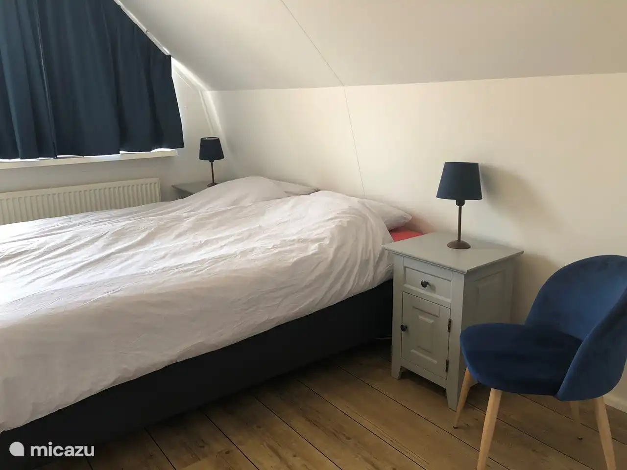 Geräumiges Schlafzimmer mit Blick auf das Dorfzentrum und den Bauernhof