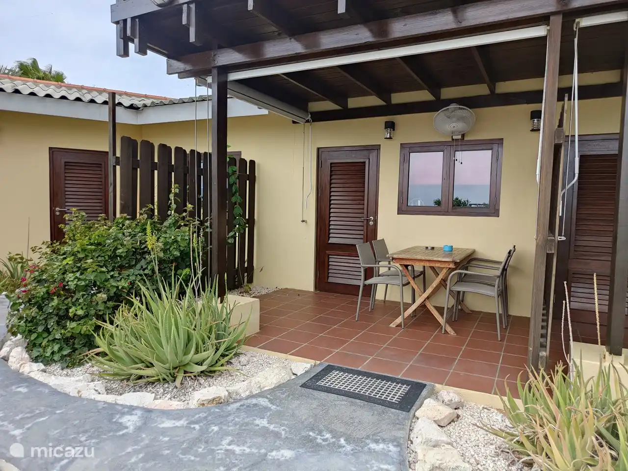 Terrasse couverte avec stores et ventilateur. Vue sur le magnifique jardin avec piscine