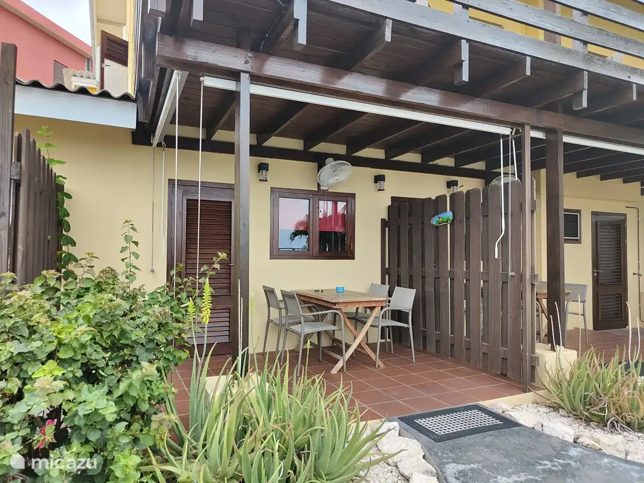 Terrasse couverte avec stores et ventilateur. Vue sur le magnifique jardin avec piscine