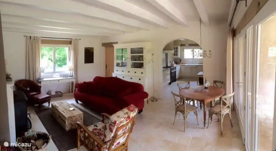 de ruime woonkamer met doorkijk naar de keuken