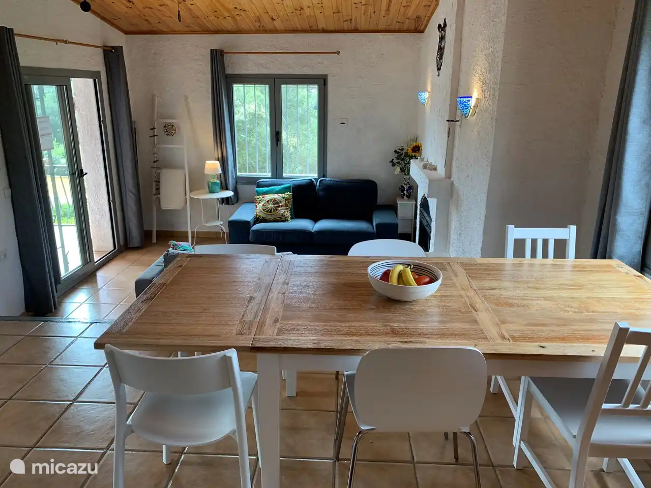 Gemütliches Wohnzimmer mit Zugang zu einer Terrasse mit Blick auf die Berge.