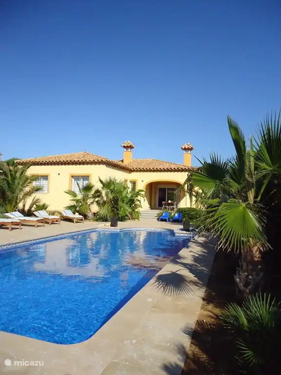 Villa TIBATI Zicht op het glasheldere grote privé zwembad met mozaïektegeltjes. Volledig omgeven door ruime zonneterrassen in natuursteen.