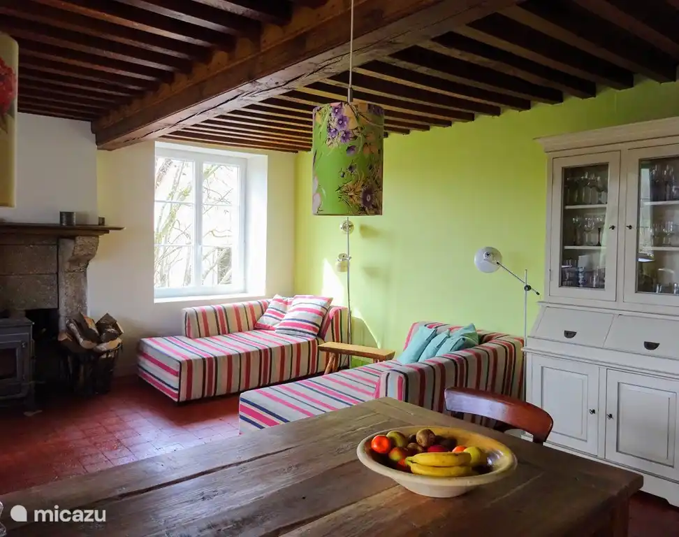 Wohnzimmer mit offener Küche und einem großen Holzofen Dovre