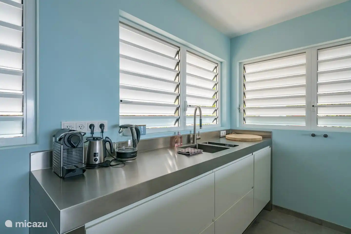 Kitchen with Nespresso coffee machine, milk frother, kettle and dishwasher.