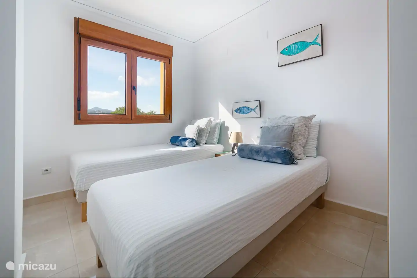 Dormitorio con dos camas individuales y aire acondicionado.