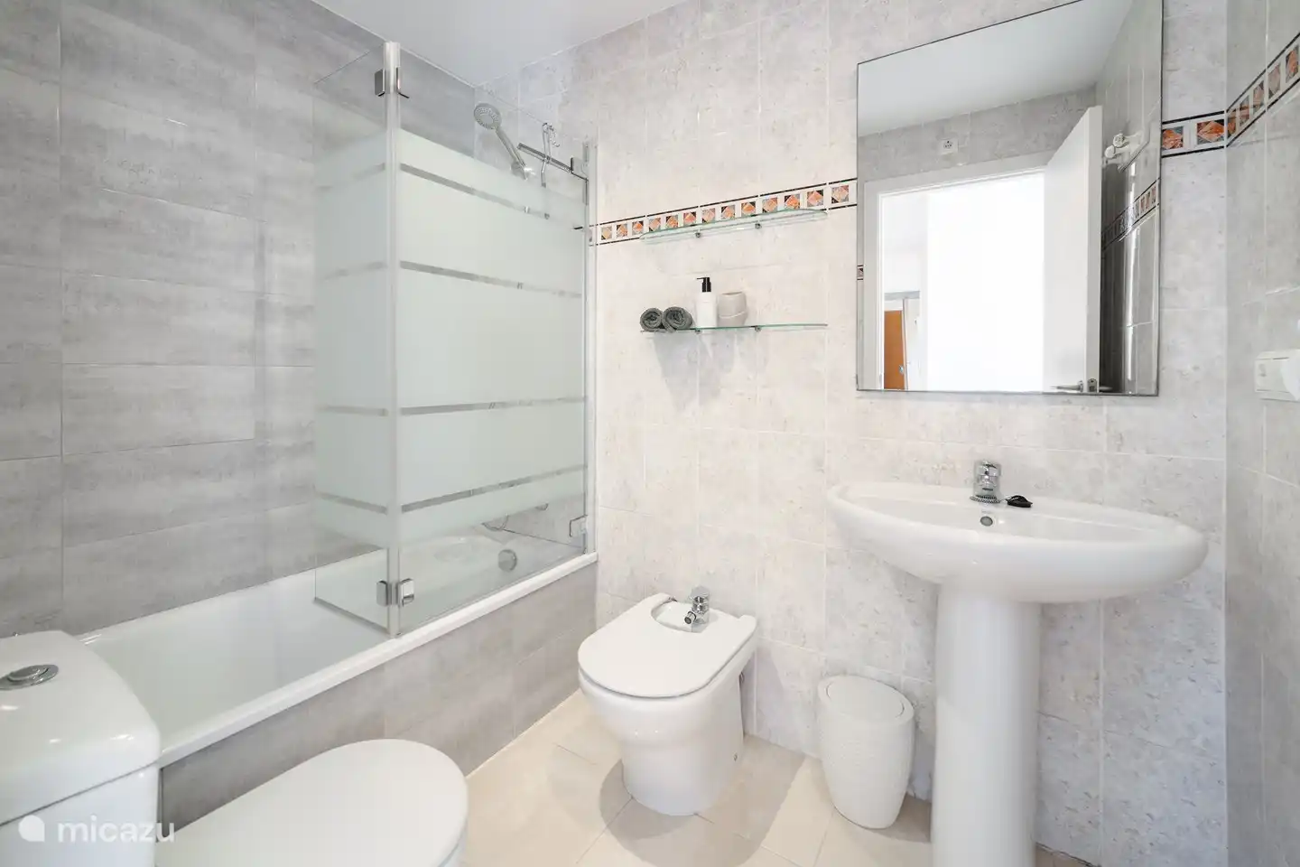 Cuarto de baño con inodoro, bidet, ducha en bañera y lavabo. Junto al dormitorio principal.