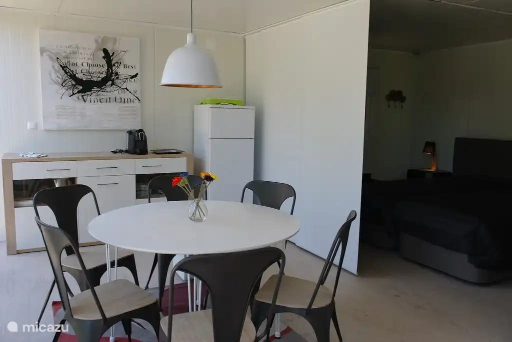 Wohnzimmer mit Küchenzeile. Der Kochbereich befindet sich draußen auf der Terrasse.