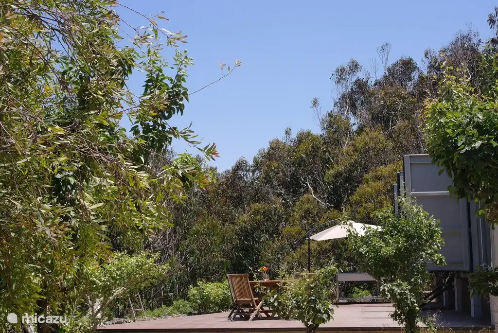 Eine schöne Terrasse mit Gartenmöbeln und einer Küche.