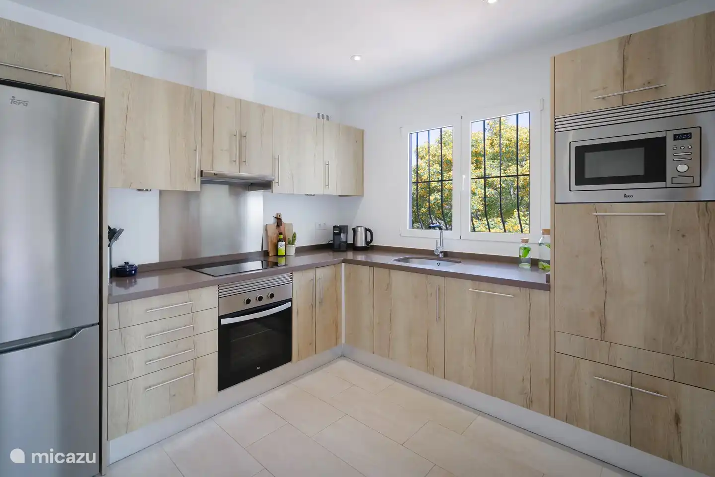 Eine moderne Küche mit allen notwendigen Geräten, einschließlich Geschirrspüler.