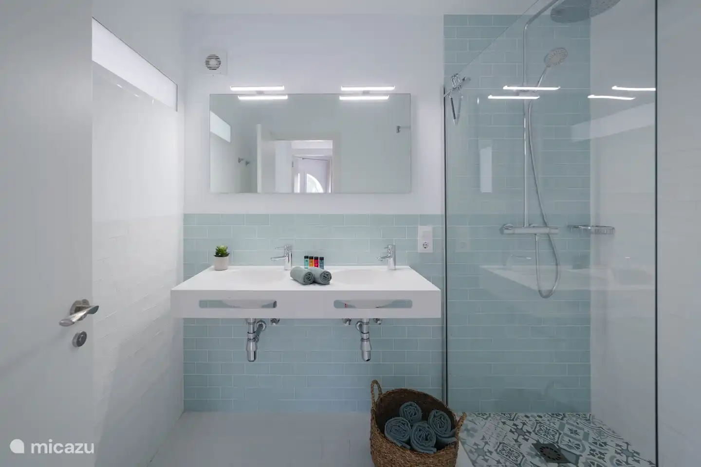 Ein geräumiges Badezimmer mit zwei Waschbecken und einer Dusche.