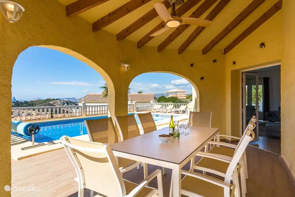 Terraza cubierta con mesa grande y sillas cómodas