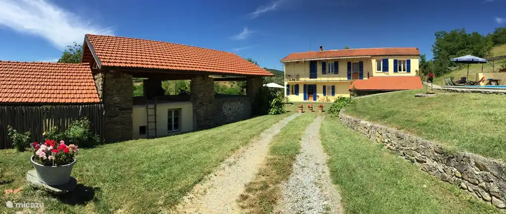 Pian del Gatto. Die Auffahrt, mit dem Stall und dem Wohnwagen unter dem Baldachin auf der linken Seite. Auf der rechten Seite das etwas höher gelegene Schwimmbad. Direkt vor Ihnen liegt das Haus mit den blauen Fensterläden.