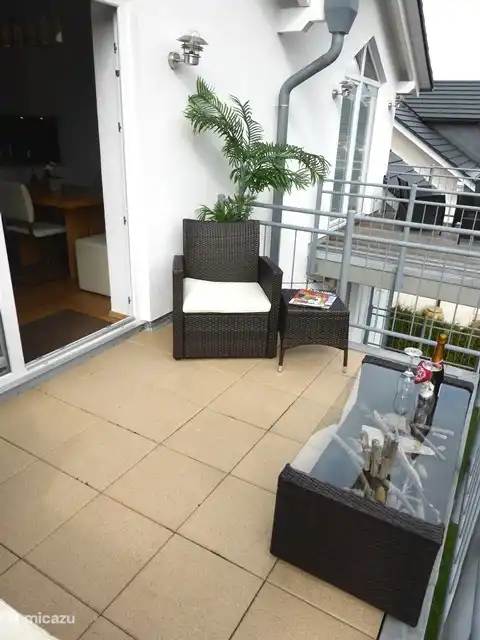 Balkon mit Sofa, Stuhl und Tisch