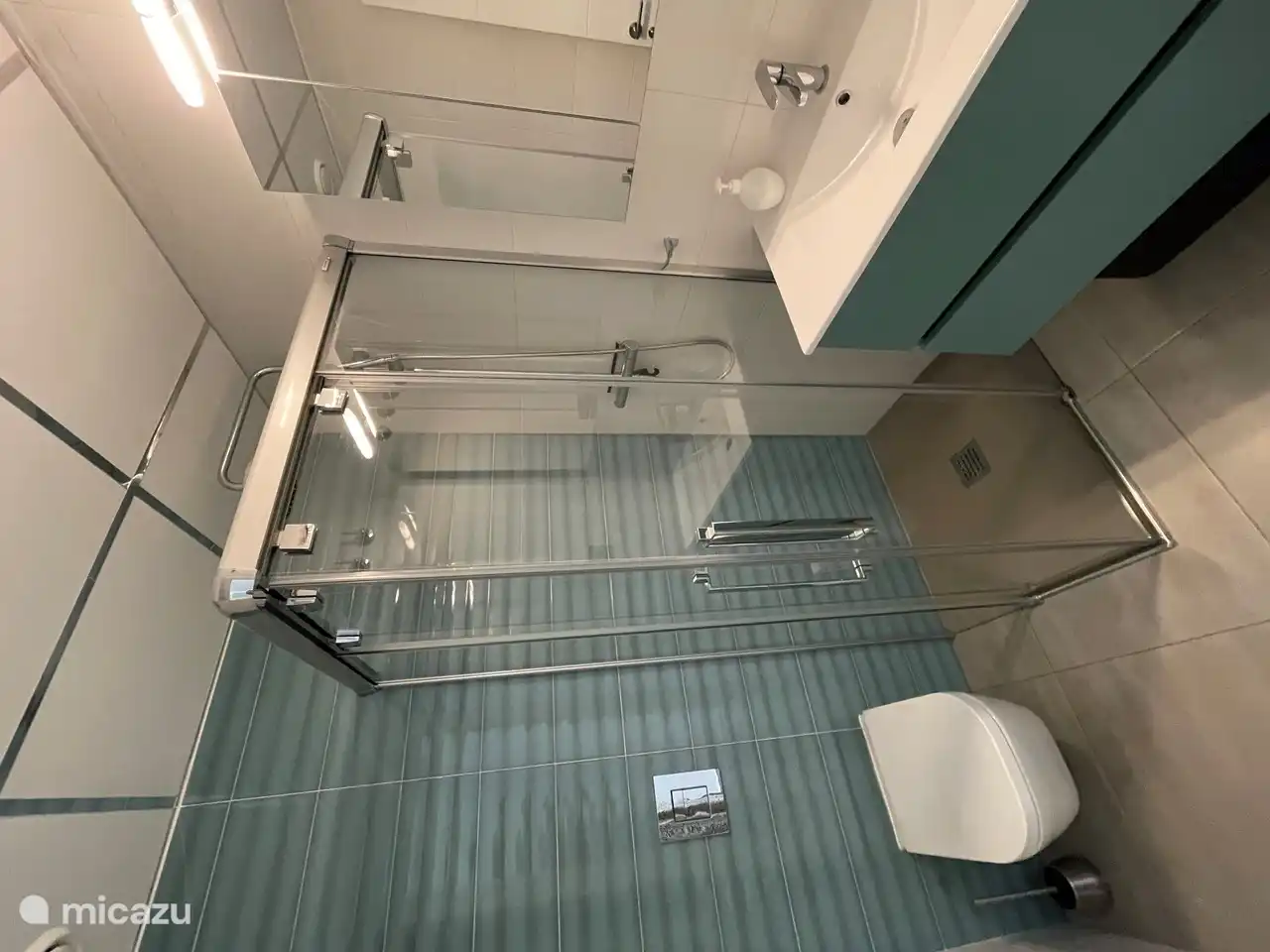 Das zweite Badezimmer mit modernen Waschbecken, Spiegelschrank, WC und regt Dusche
