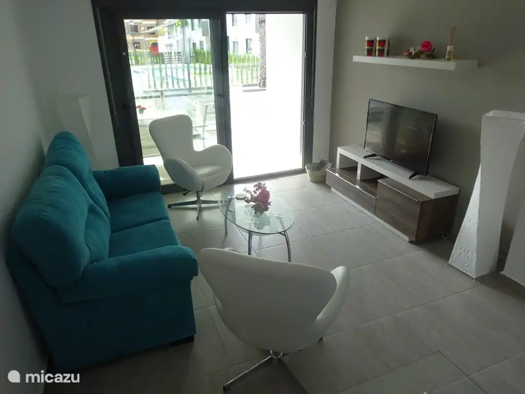 Das Wohnzimmer von der Küche mit großen Sofa und zwei Sesseln gesehen