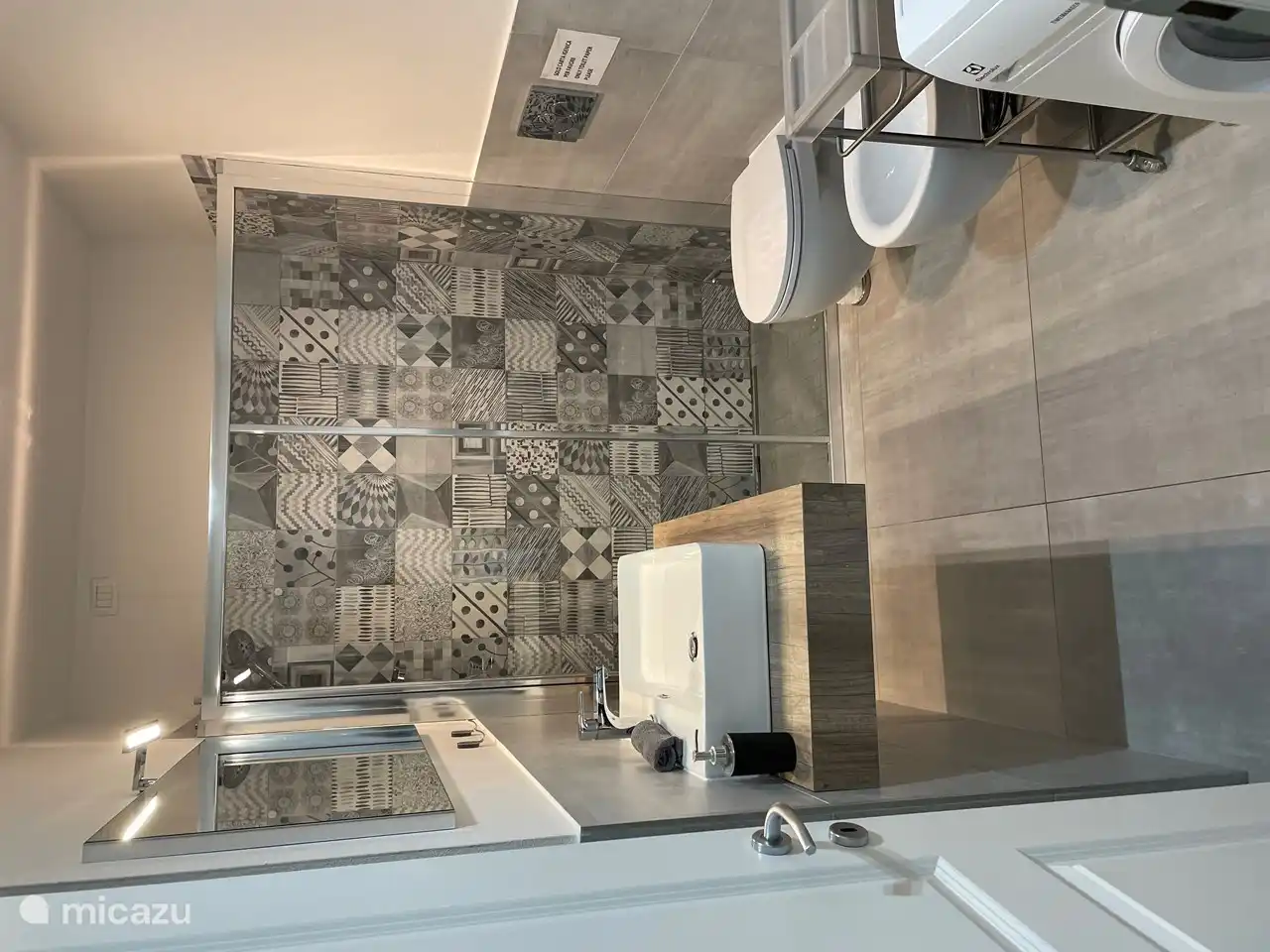 Cuarto de baño, con ducha, inodoro, bidé y lavadora.