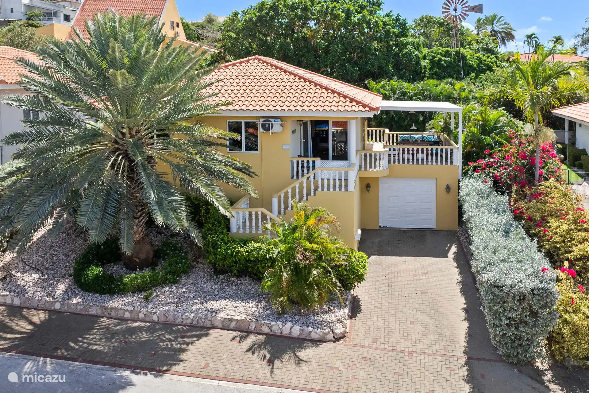 Villa avec vue de face et beaucoup de verdure.
