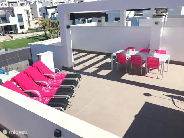 Penthouse Casa Esmeralda | Espagne, Costa Blanca, Torrevieja - appartement Terrasse sur le toit avec vue sur la mer, douche extérieure, transats, cuisine extérieure, barbecue et table à manger 6 places. Au-dessus de la table à manger se trouve un parasol facilement extensible.