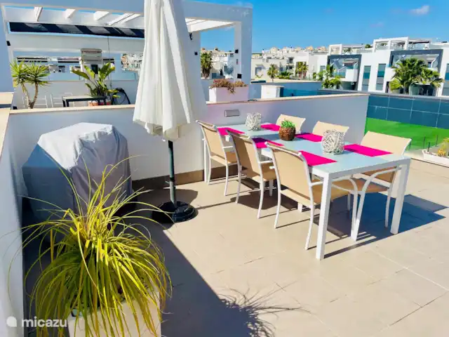 Penthouse Casa Esmeralda | Espagne, Costa Blanca, Torrevieja - appartement Sur le toit-terrasse, vous trouverez une jolie table à manger pour 6 personnes. Profitez d'un barbecue et d'un dîner sous le parasol avec vue sur la piscine et Torrevieja. C'est le sentiment de l'Espagne.
