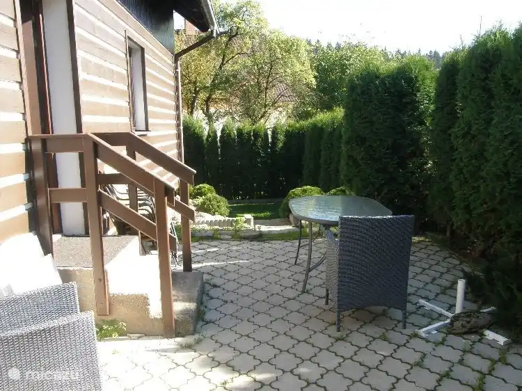 Vanuit de woonkamer komt men op de zithoek in de tuin.