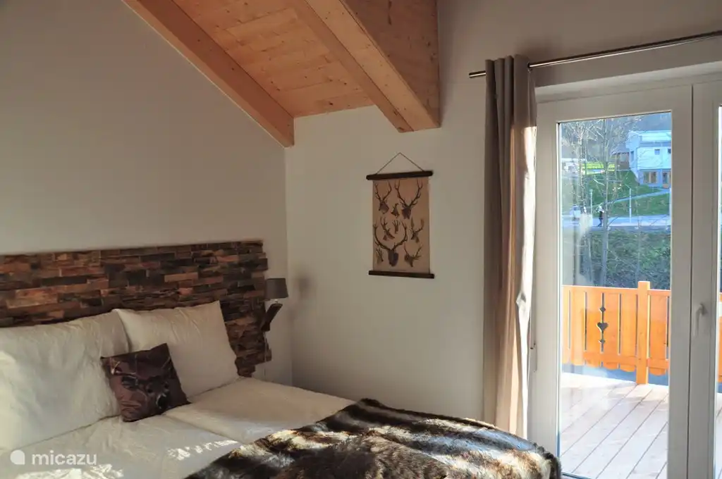 Chambre 1 avec un lit double, balcon et vue sur la piste de ski