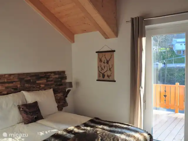 Berghaus Christel en Austria, Carintia, Arnoldstein - casa vacacional Dormitorio 1 con cama doble, balcón y vista a la pista de esquí