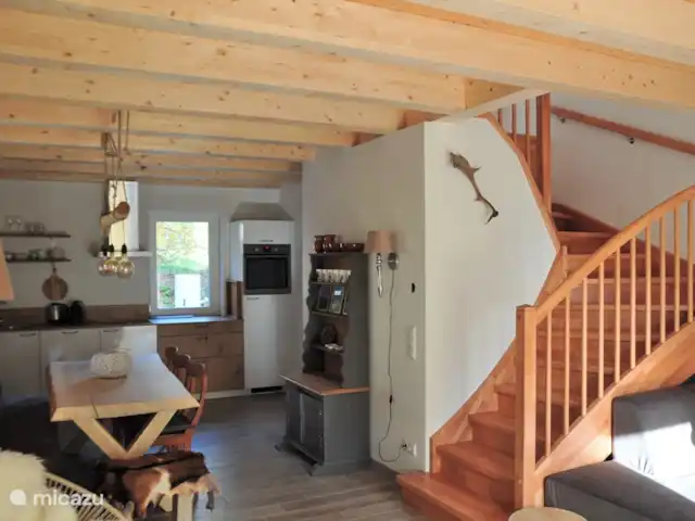 Berghaus Christel en Austria, Carintia, Arnoldstein - casa vacacional Sala de estar con mesa de comedor de tronco de árbol. La casa está amueblada en estilo Chalet. Hermosas vigas en el techo, también en el 1er y 2do piso, les dan un ambiente extra.