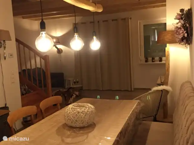 Berghaus Christel en Austria, Carintia, Arnoldstein - casa vacacional ambiente en la sala de estar por la noche. Es maravilloso cenar en la mesa del tronco del árbol.