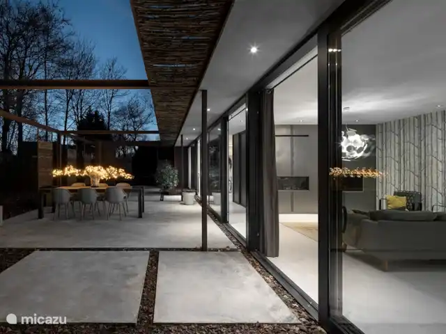 Maison forestière en acier | Pays-Bas, Brabant-Septentrional, Oosterhout - maison de vacances Côté de la maison avec de grandes portes coulissantes qui fournissent beaucoup de lumière. Accès direct à la terrasse où se trouvent le sauna et le bain à remous.