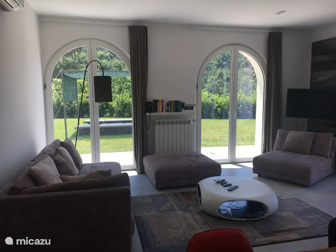 Woonkamer met gordijnen open en toegang tot prive tuin