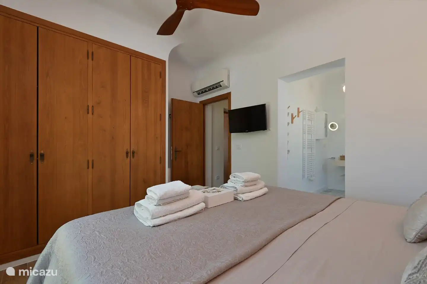 Chambre principale Casa ZenZeZ avec 2 grandes armoires encastrées / ventilateur design en bois et portes-jardin avec terrasse sur le côté de la casa avec vue panoramique sur les montagnes