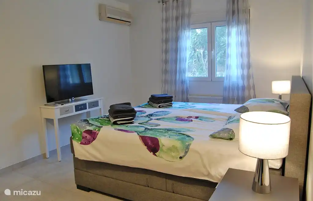 Das Hauptschlafzimmer mit bequemen Betten sowie TV und Klimaanlage.