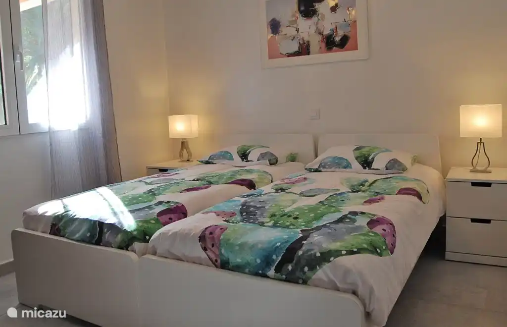 Das Gästezimmer mit Klimaanlage und Rollläden an den Fenstern.