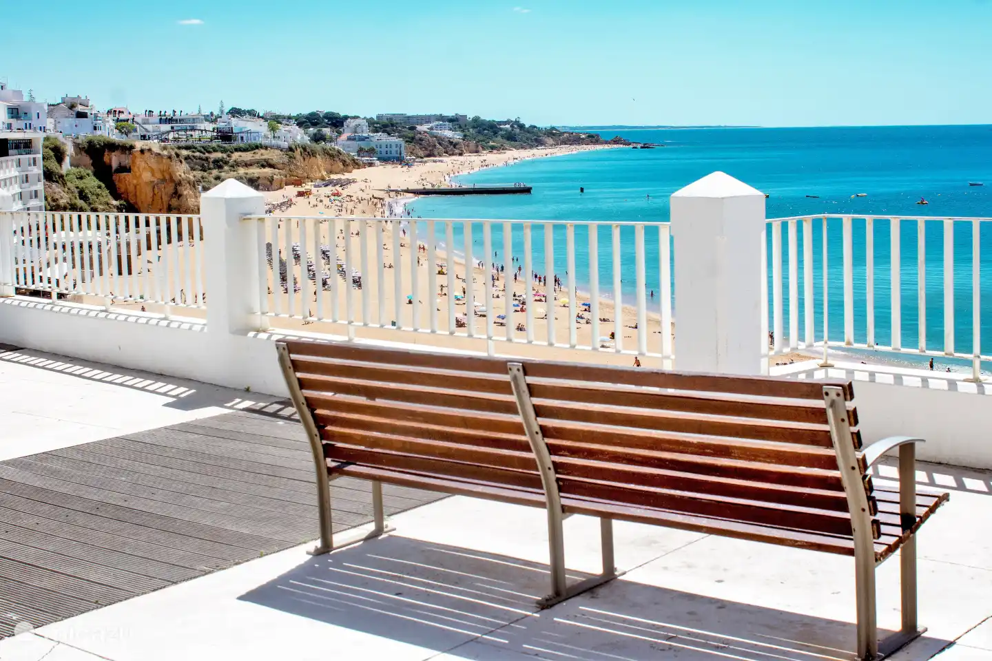 Neem even tijd voor een ijsje op dit bankje, met prachtig uitzicht over het strand bij het centrum van Albufeira.