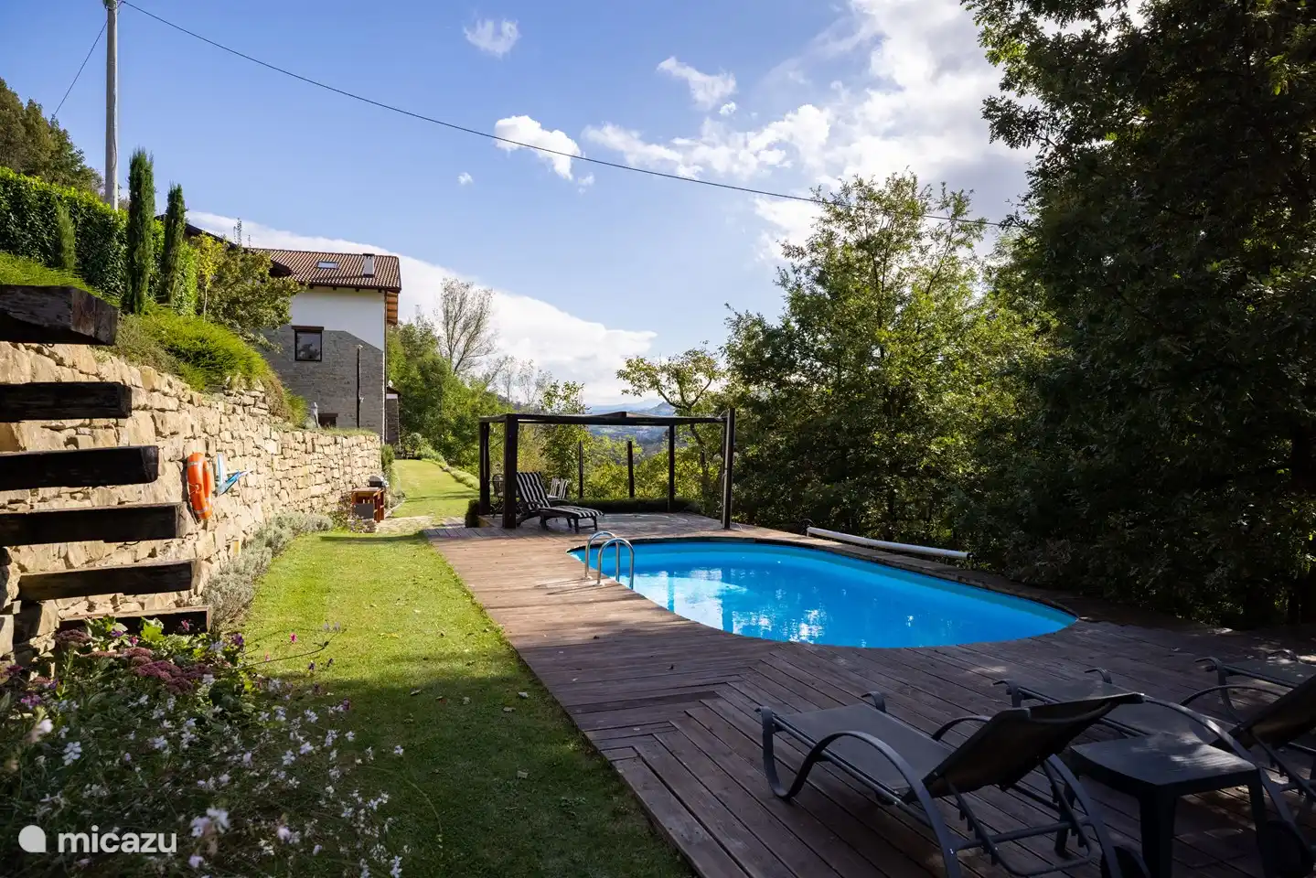 Foto der Seite der Villa Lucciola. Auf mehreren Terrassen können Sie am Nachmittag den Schatten der Bäume oder die Sonne genießen. Es gibt einen Swimmingpool, einen Whirlpool und eine Außenküche mit Holzofen und Grill. Im Oktober/November pflanzen wir Bäume als CO2-Ausgleich für Ihren Urlaub.