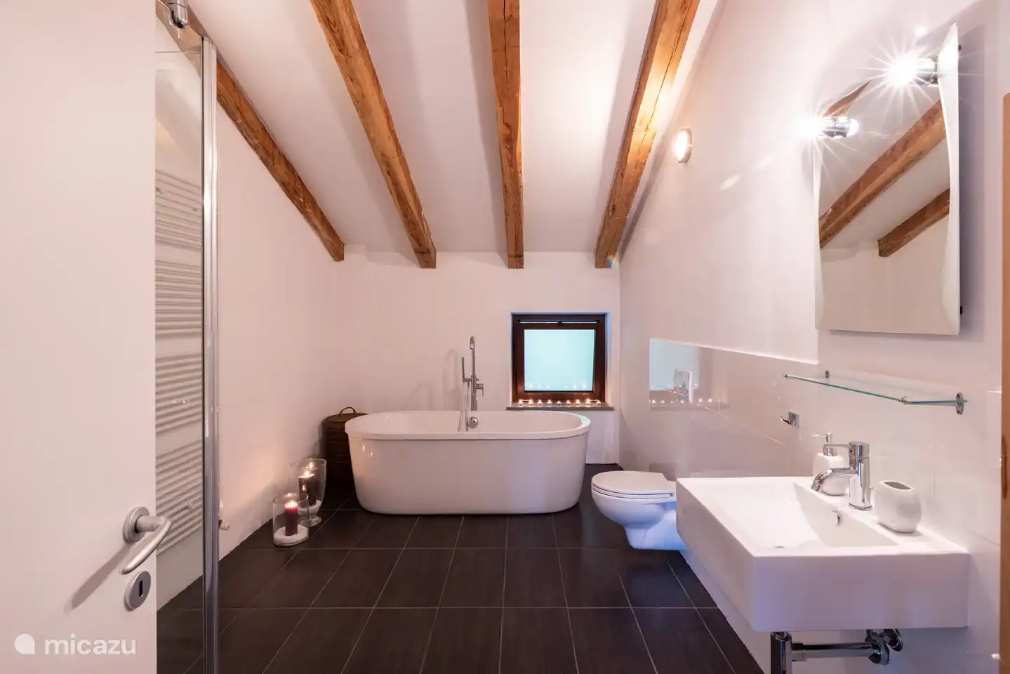 Badezimmer im 1. Stock mit ebenerdiger Dusche und freistehender Badewanne.