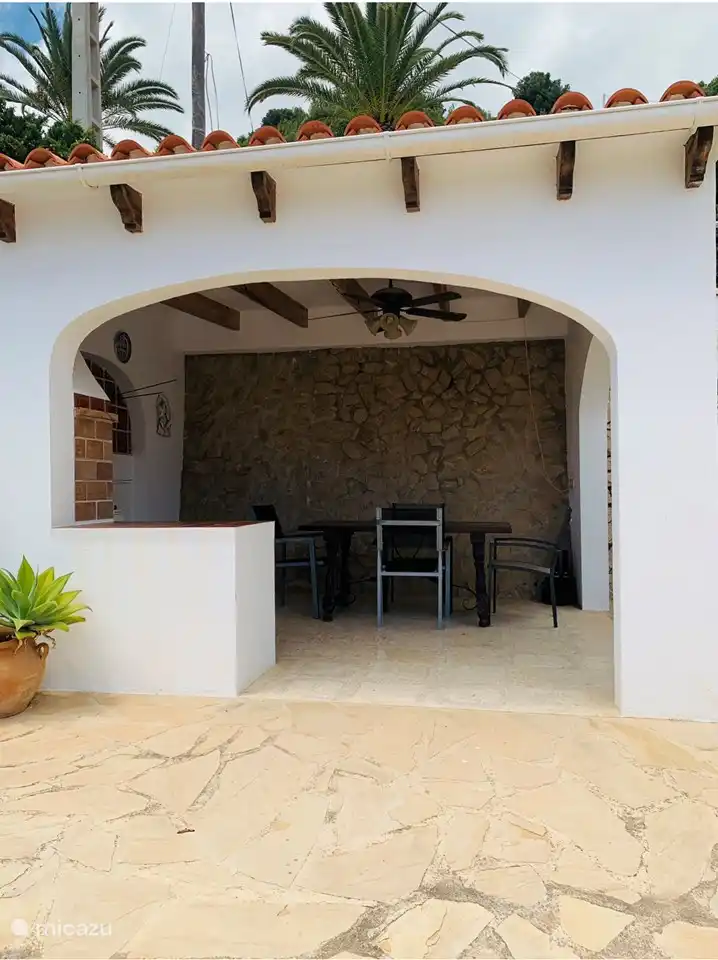 Die gemütliche Außenküche mit Tisch und Stühlen