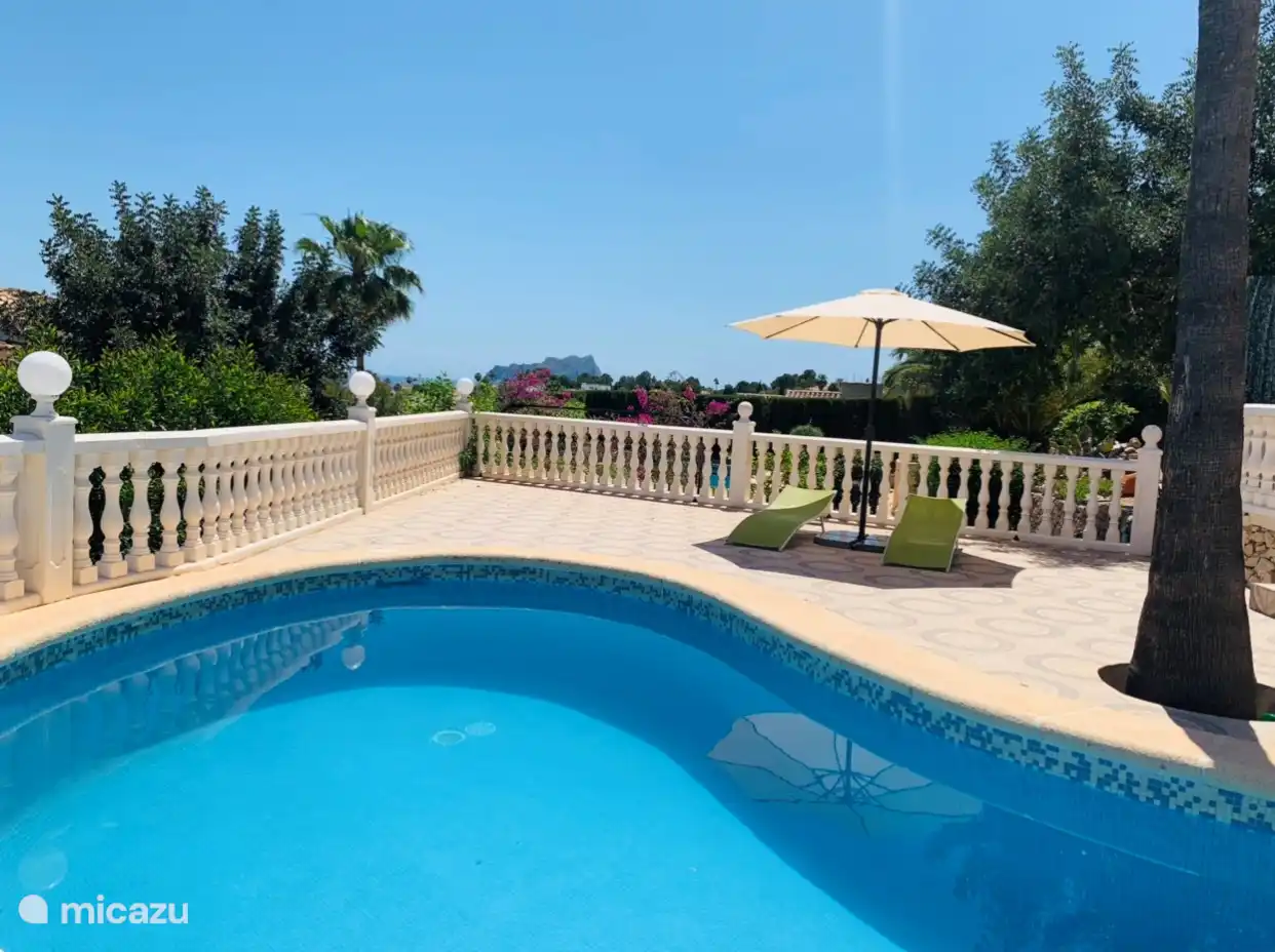 Swimmingpool mit Liegestühlen und Sonnenschirm