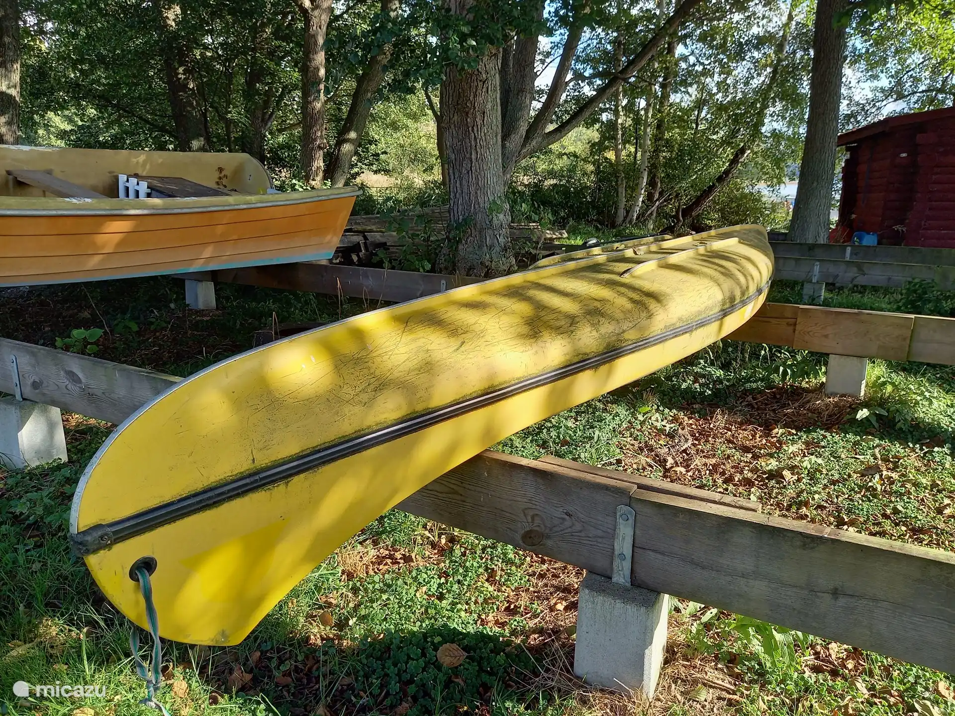 Das Kanu liegt auf einem Holzgerüst im Hafen und ist bereit, den See zu erkunden.