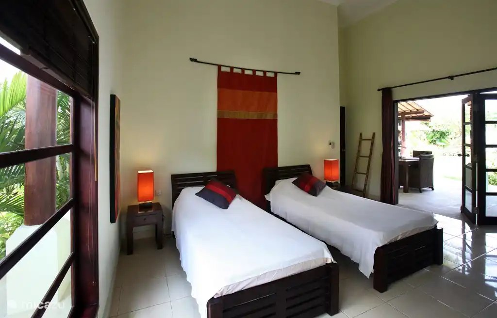 Mittleres Schlafzimmer mit zwei Einzelbetten, Waschbecken und Duschbad.