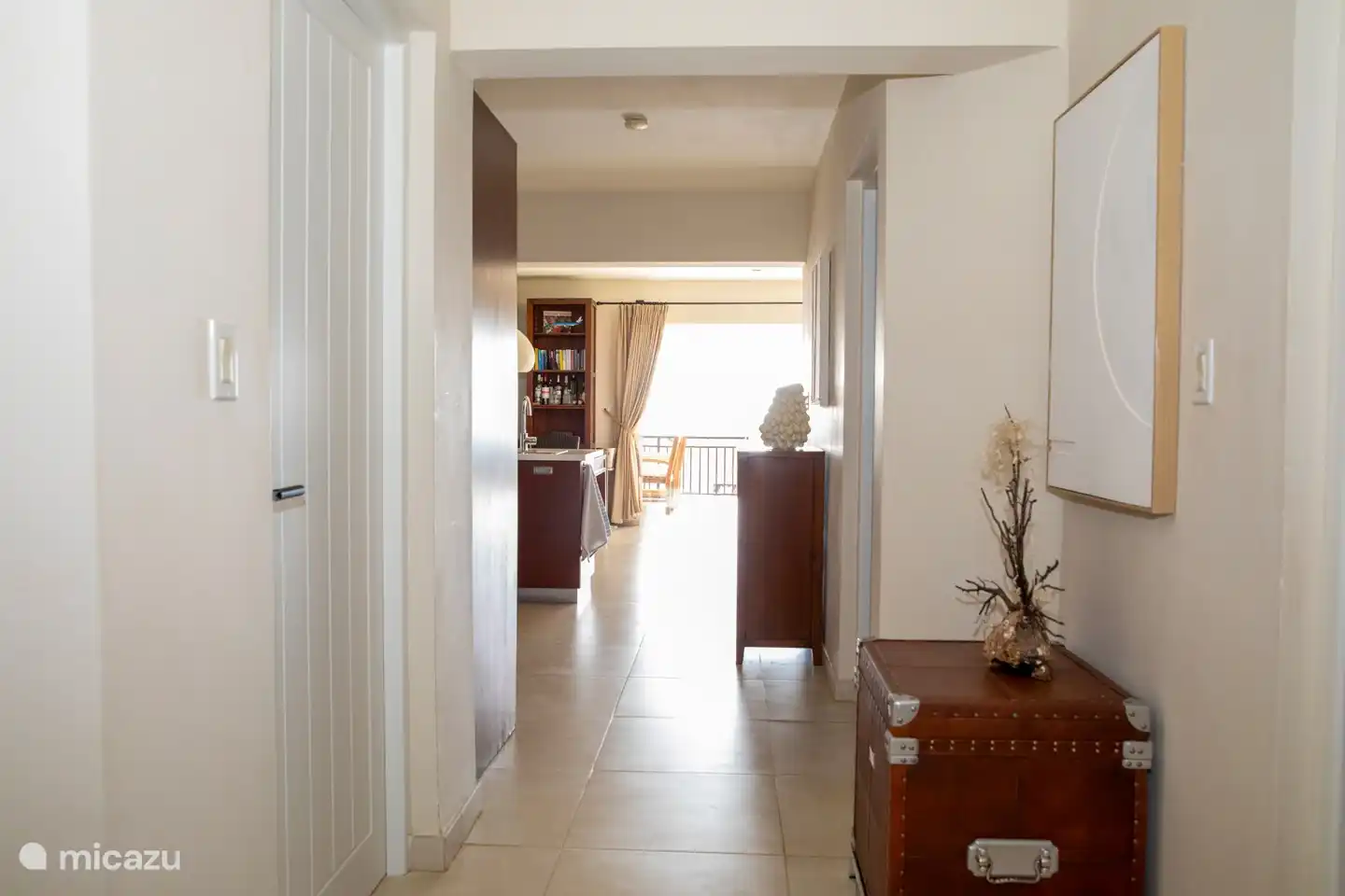 De 2e verdieping gelegen appartement hal met toegang tot woonkamer voorzien van schuifdeuren naar riant overdekt terras aan zeezijde