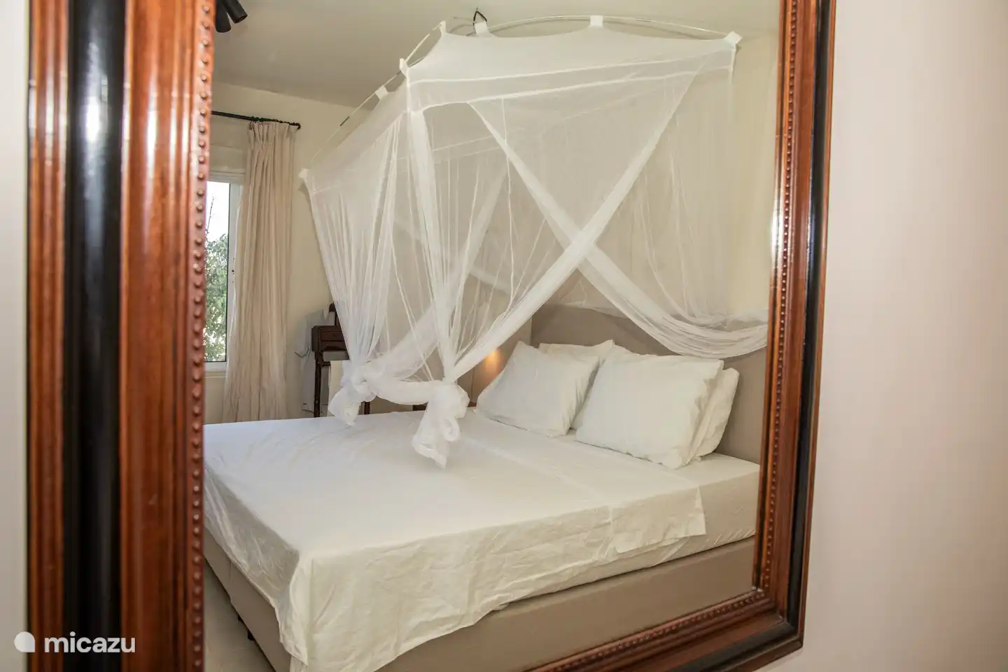 Slaapkamer met heerlijk nieuw bed voorzien van airco en een klamboe.