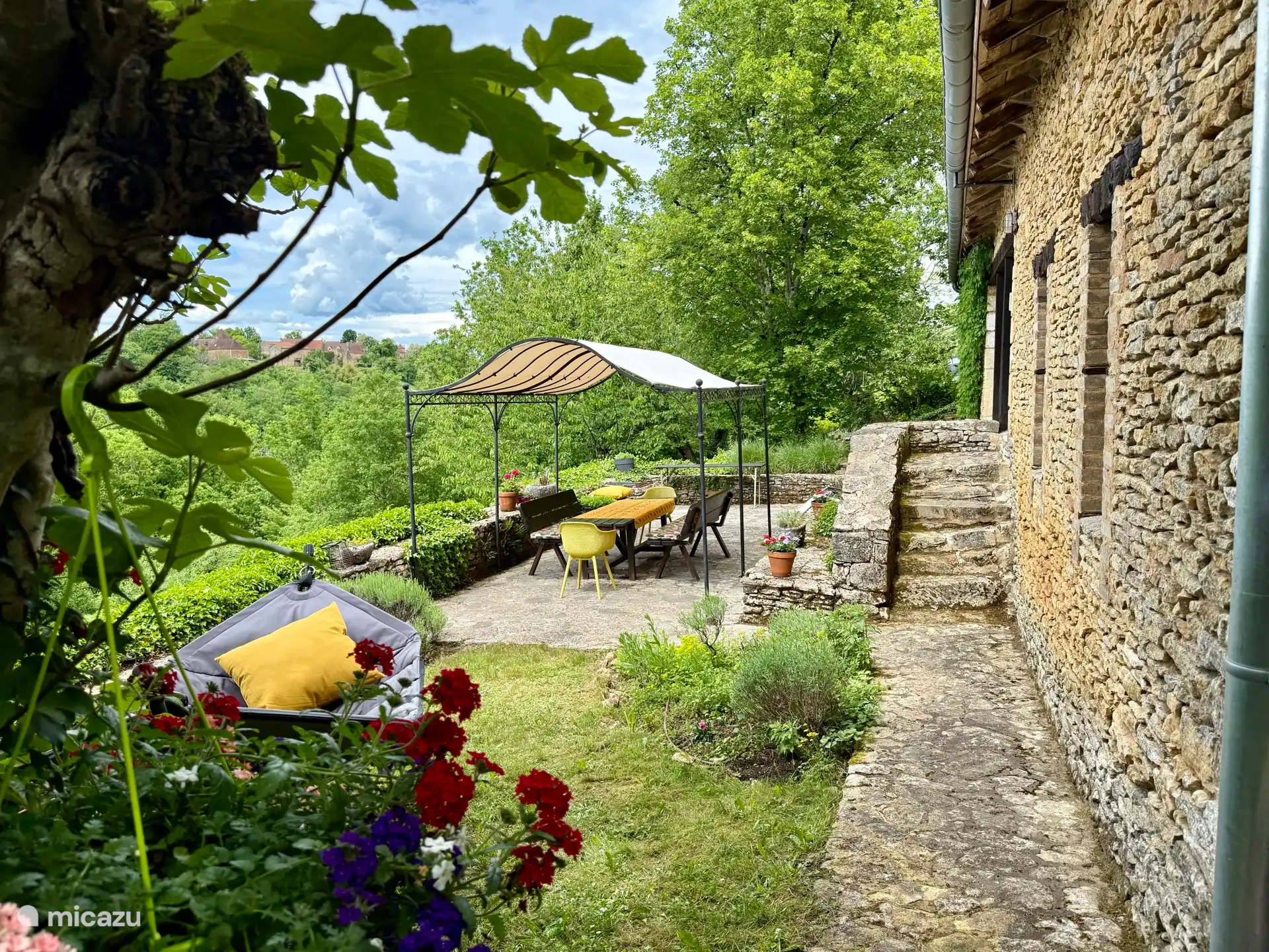 Die Terrasse mit Hängematte, großem Tisch und Bänken
